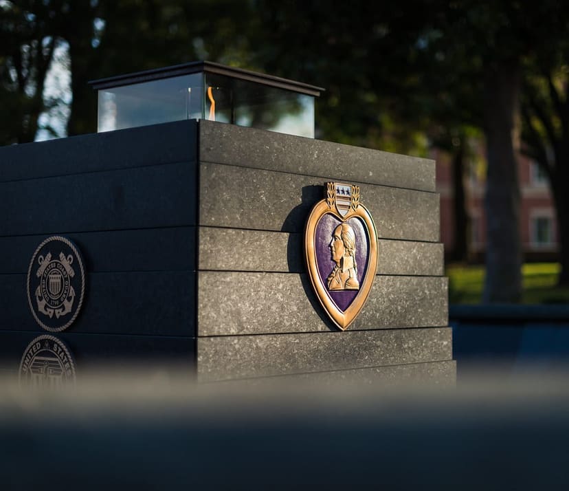 Purple Heart and military service emblems on the eternal-flame memorial at Veterans Park in Kannapolis