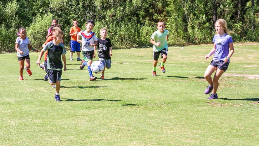 Children playing soccer on the field at Eliza Pool Park
