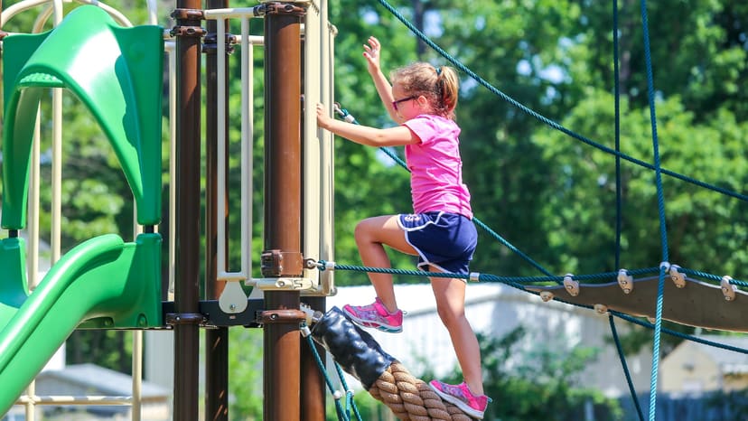 Child climbing the rope feature at Mary Belle Pate Park