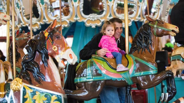Child riding the historic Pullen Park carousel