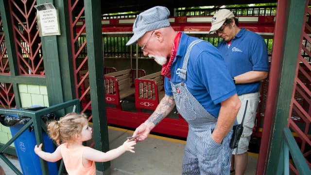 Child giving a ticket to the Pullen Park train conductor
