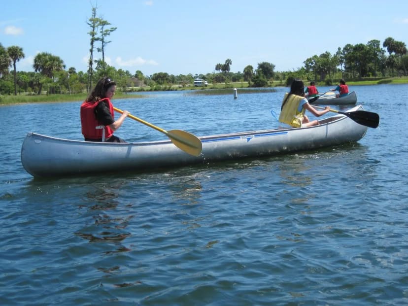 Visitors paddling canoes on a lake at Okeeheelee Park