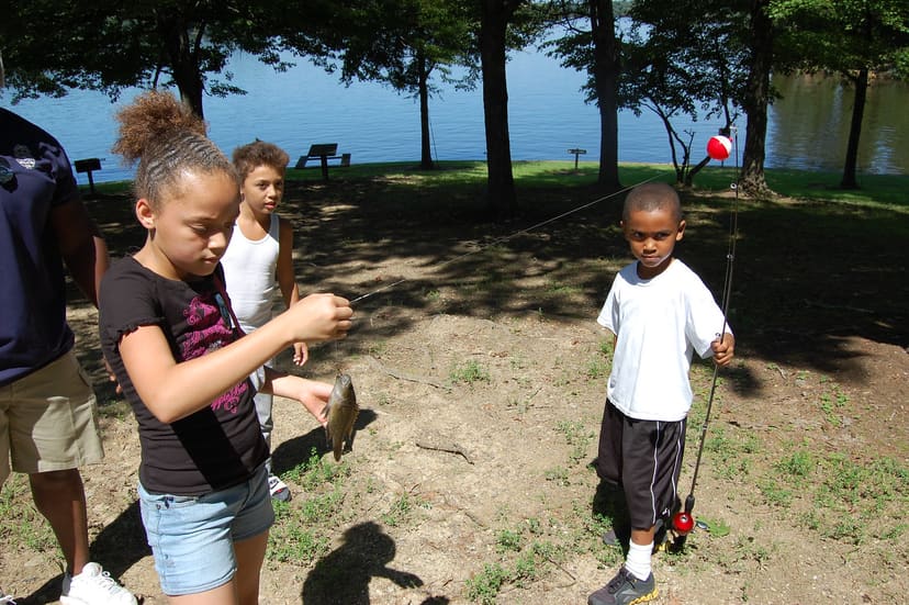 Children fishing from the shaded shoreline at Lake Mackintosh Park and Marina