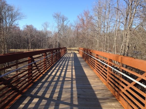 Paved Walnut Creek Greenway through a wooded corridor